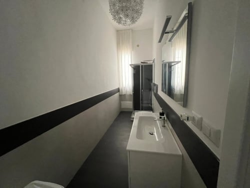 Bagno moderno nell'appartamento fronte mare di Marina di Strongoli con doppio lavabo, specchio e design contemporaneo bianco e nero