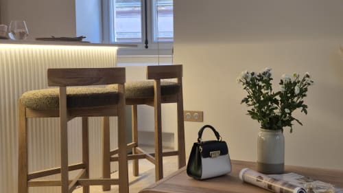 Modern zitgedeelte in Moulin Renaudiots in Autun met houten barkrukken, handtas, bloemen en stadsuitzicht