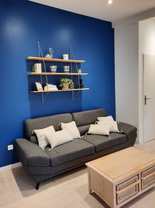 Coin salon chaleureux avec canapé et mur décoratif à Le Clos Bussy à Vichy.