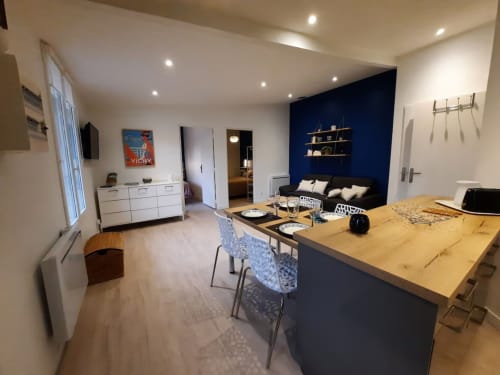 Bright open-plan living area with fully equipped kitchen and comfortable lounge at Le Clos Bussy near Vichy.