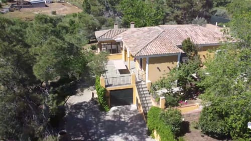 Vista aérea de la Finca Navalpino B&B en Guadamur, España, con edificios de tonos ocre amarillento y tejados de barro rodeados de árboles