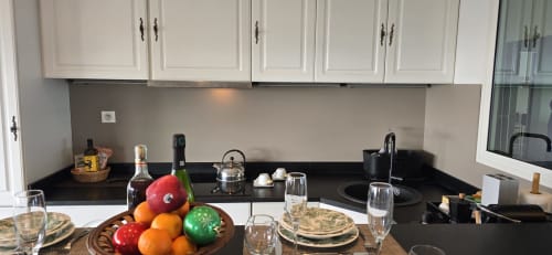 Cucina moderna nell'appartamento La Dolce Vita a Campagnano di Roma, con piani neri, mobili bianchi e zona pranzo