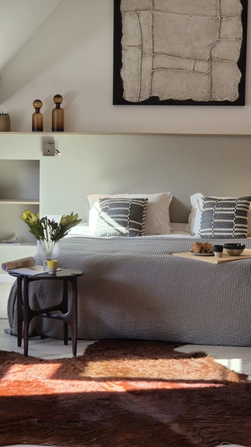 Moderne slaapkamer in Moulin Renaudiots met grijze gestoffeerde bed, gemusterde kussens en minimalistisch inbouwkasten in Autun, Frankrijk