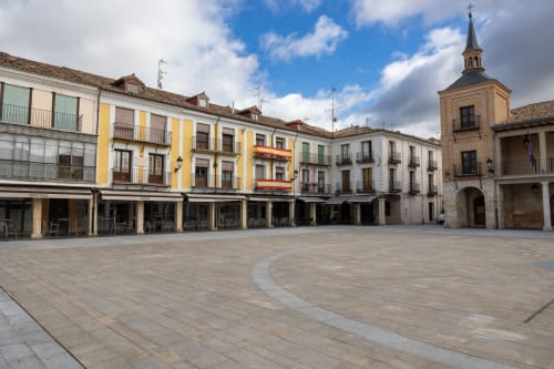 Plaza histórica en Burgos, España con coloridos edificios coloniales y torre de iglesia en el hotel Unique Rooms