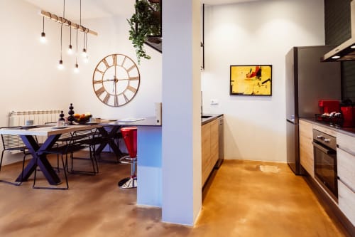 Moderno loft en Burgos con cocina abierta, comedor, lámparas colgantes y suelos de madera
