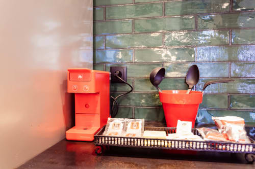 Cafetera roja y utensilios de cocina en apartamento Loft Center Burgos con azulejos verdes tipo metro