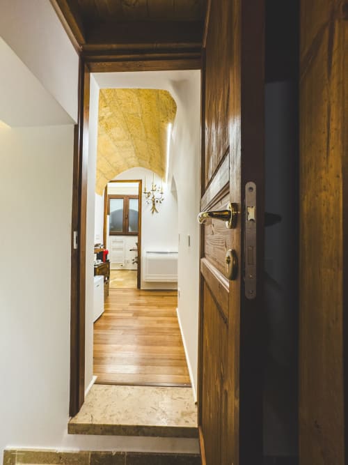 Ingresso in legno dell'appartamento CorteLirice Paradiso con corridoio, pavimenti in parquet e pareti bianche