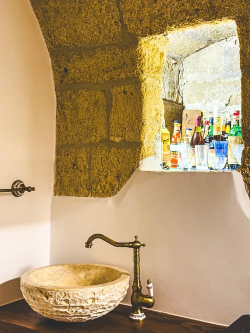 Lavabo rustico con rubinetto in ottone e bacino in pietra presso l'appartamento CorteLirice Paradiso, Italia