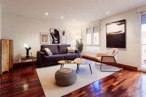 Moderno salón de apartamento en Burgos con sofá púrpura, pisos de madera, vistas a la ciudad y arte contemporáneo