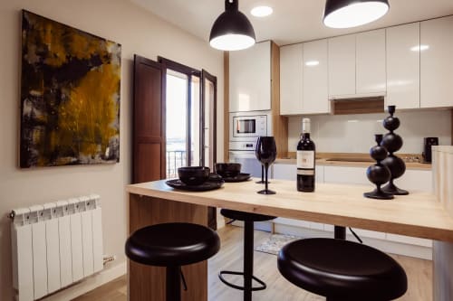 Cocina y comedor modernos en el apartamento Arco San Esteban, Burgos, con encimeras de madera, taburetes negros y vistas a la montaña