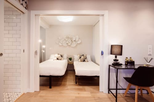 Dormitorio moderno en el apartamento Arco San Esteban de Burgos con dos camas individuales, suelos de madera y decoración contemporánea
