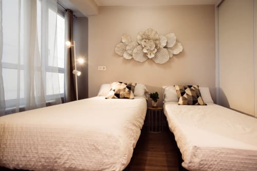 Dos camas gemelas en habitación de apartamento moderno en Unique Rooms, Burgos con decoración beige y arte mural decorativo