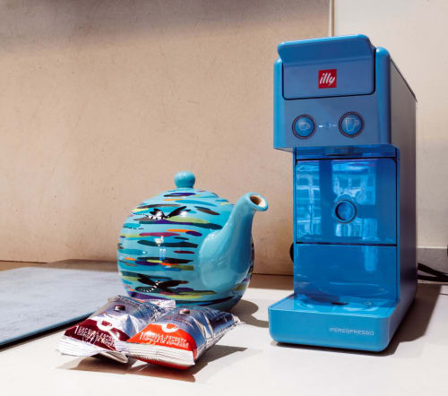 Máquina de espresso Illy azul con tetera colorida y cápsulas de café en apartamento Unique Rooms, Burgos