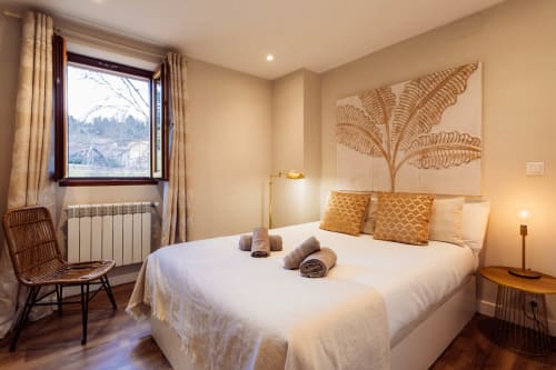 Elegante dormitorio en The Charm of Twelve, Burgos con vistas a la ciudad, detalles dorados y mobiliario moderno