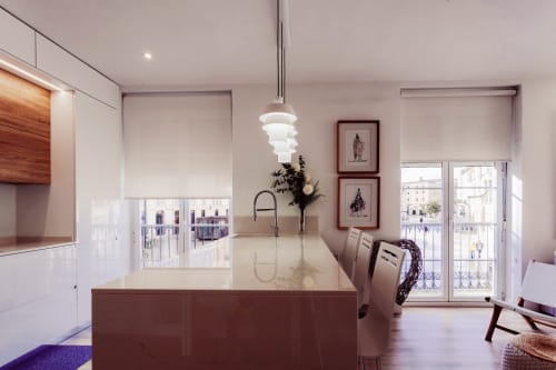 Cocina moderna y sala de estar en apartamento de Burgos con vistas al balcón hacia la Catedral, con muebles blancos y madera