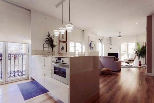 Cocina y sala de estar integradas y modernas en apartamento Five Balconies, Burgos, con muebles blancos, piso de madera