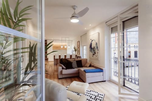 Moderno salón de apartamento con sofá, vistas al balcón de la Catedral de Burgos, pisos de madera y mobiliario contemporáneo en