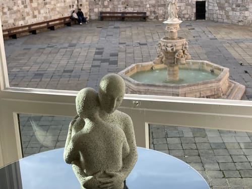 Escultura de piedra en mesa con vistas al patio de la Catedral de Burgos y fuente desde apartamento Unique Rooms