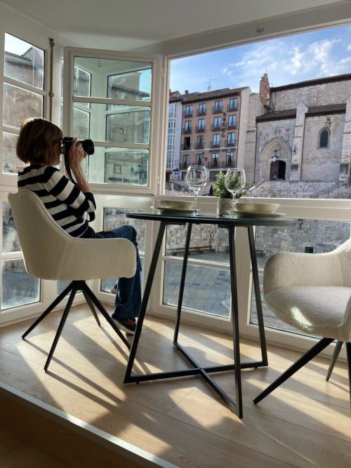 Mujer fotografiando la vista de la Catedral de Burgos desde la ventana de un apartamento moderno en el hotel Unique Rooms