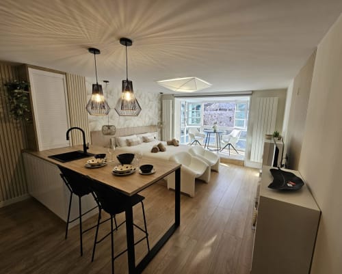 Apartamento moderno en Unique Rooms Burgos con comedor, cocina, cama y vistas a la catedral a través de puertas de cristal