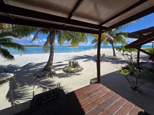 Tikehau beachfront bungalow terrace with sea views, palm trees, and white sand beach in French Polynesia