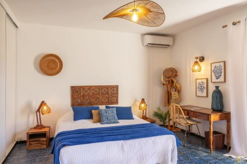 Spacieuse chambre à la Villa Annonciade, Centuri Corse, avec accents bleus, tête de lit en bois et décor côtier