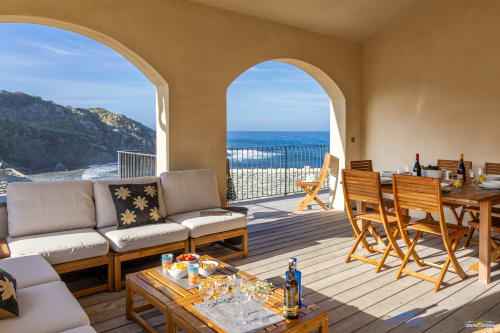 Terrasse de la Villa Annonciade avec vue mer, mobilier en bois et côte de Centuri à La Conciergerie du Cap Corse