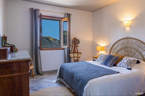 Spacieuse chambre de la Villa ANNONCIADE à La Conciergerie du Cap Corse, Centuri, vue mer, tête de lit en rotin, literie bleu
