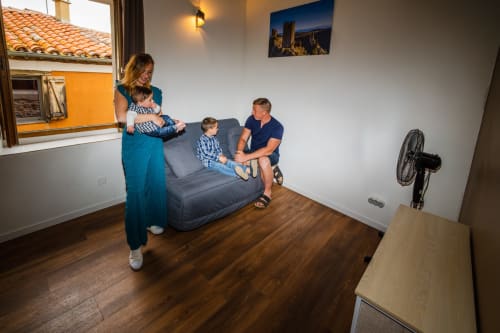 Famille se détendant au cottage École du Château De Villelongue avec coin salon et ventilateur