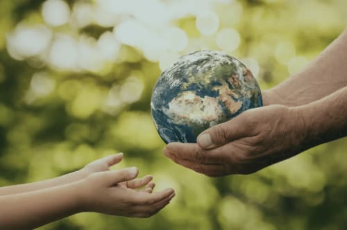 Adult and child hands sharing a globe in nature at Au Château De Villelongue, Villelongue-d'Aude