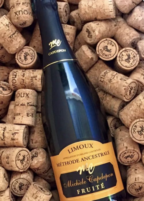 Botella de vino espumoso Capderpon rodeada de corchos en el Château de Villelongue, Villelongue-d'Aude