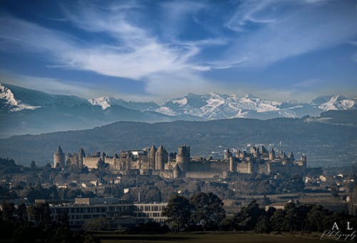Castillo medieval que domina Villelongue-d'Aude con los Pirineos nevados de fondo bajo un cielo azul