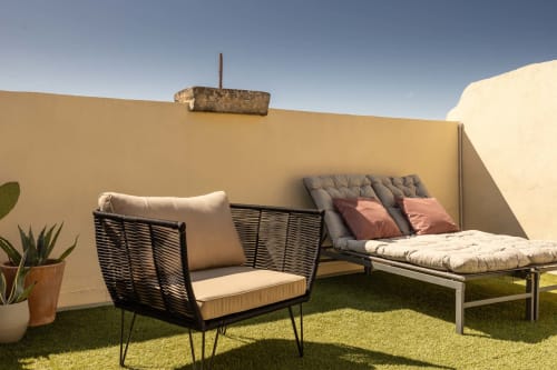 Rooftop terrace with black wicker chairs and daybed at Le Prieuré Notre-Dame, Montfrin
