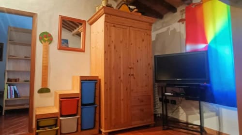 Camera da letto accogliente con arredamento in legno, TV a schermo piatto, illuminazione RGB colorata e armadi di stoccaggio a Torre Della