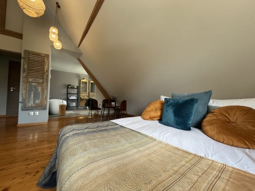 Chambre loft moderne à Théière & Couverts à Cernay avec poutres en bois, suspensions et mobilier contemporain