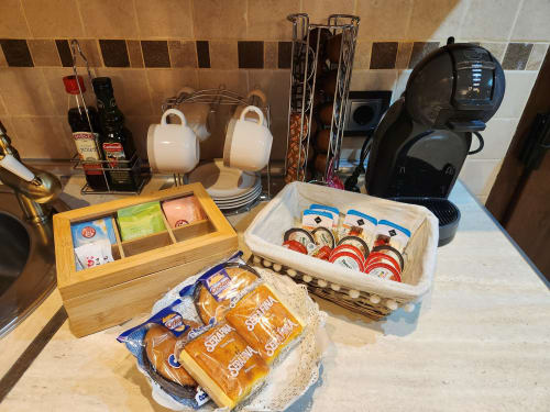 Mostrador de cocina en la casa rural Fuente Vieja con estación de té y café, tazas, snacks y cafetera en Arbancón