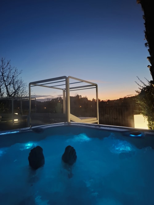 Two guests enjoying Villa Colina's illuminated hot tub at dusk in Mandelieu la Napoule, France