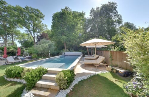 Espace piscine luxe au Pavillon Des Millesimes SPA à Lussac avec transats, parasol et jardins paysagés