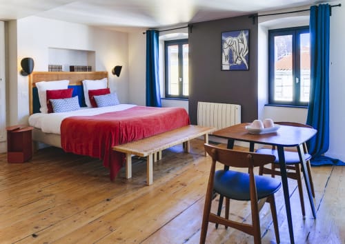 La chambre Sancy à La Tour Grégoire à Clermont-Ferrand propose un lit aux accents rouges, des rideaux bleus, des parquets et