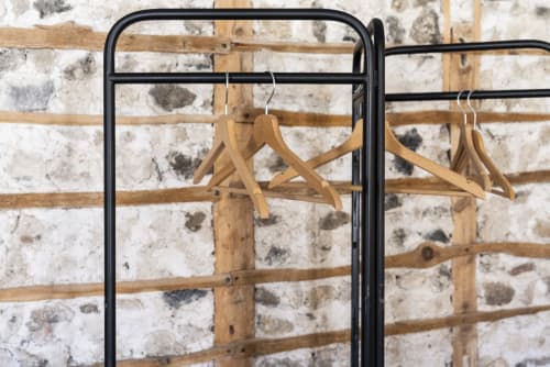 Cintres en bois sur portant à vêtements en métal noir à la chambre d'hôtes La Tour Grégoire, Clermont-Ferrand