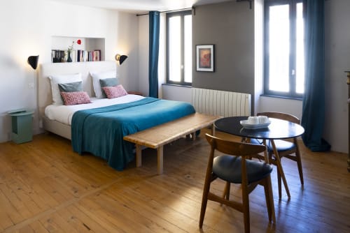 Chambre moderne à La Tour Grégoire à Clermont-Ferrand avec literie bleue, bureau en bois et vue sur la ville
