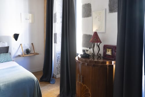 Chambre Pavin au gîte La Tour Grégoire à Clermont-Ferrand avec lit, commode en bois, lampe et rideaux sombres