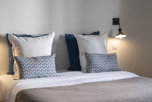 Lit moderne aux draps blancs et oreillers bleus à motifs à La Tour Grégoire, Clermont-Ferrand