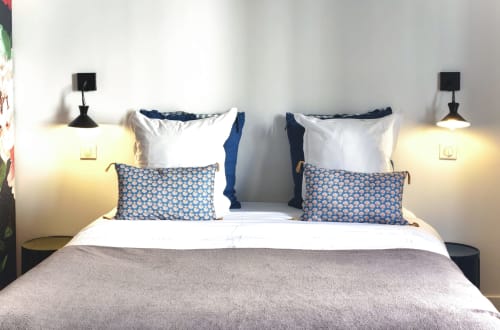 Chambre moderne à La Tour Grégoire B&B à Clermont-Ferrand avec lits jumeaux, oreillers à motifs bleus, linges blancs et noir