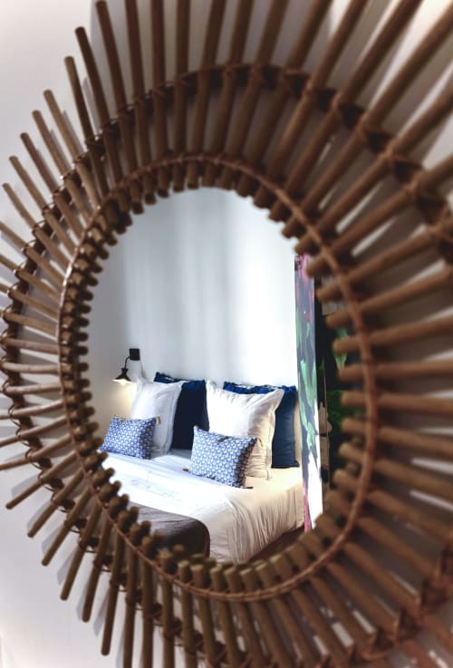 Chambre de La Tour Grégoire B&B à Clermont-Ferrand reflétée dans un miroir soleil décoratif, avec un lit bleu