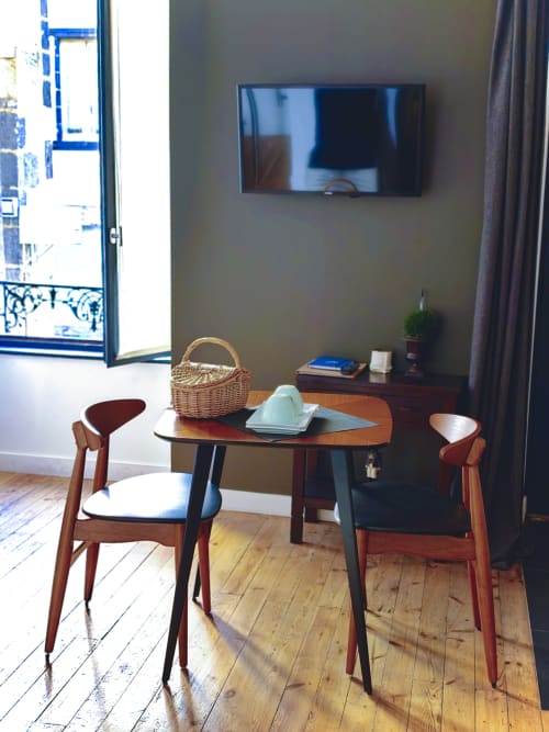 Chambre Guéry à La Tour Grégoire à Clermont-Ferrand : table de salle à manger mi-siècle avec chaises en bois, téléviseur mural et