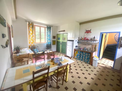 Bright cottage interior with dining table, kitchen, and colorful accents at Le Lama Zébré, Penmarch