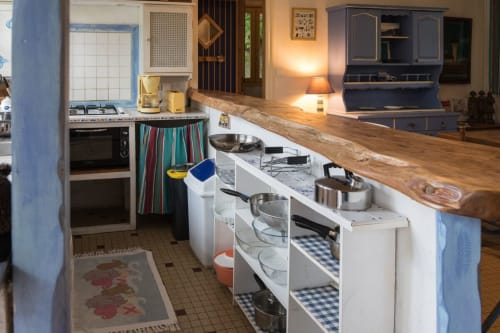 Kitchen in The Fisher Sheep Cottage at Le Lama Zébré, a Penmarch BnB, featuring stove, oven, wooden countertop, and dining