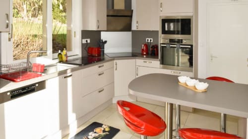 Cuisine équipée de l'Appartement 2 Personnes - four, lave-vaisselle, hotte et tabourets rouges design