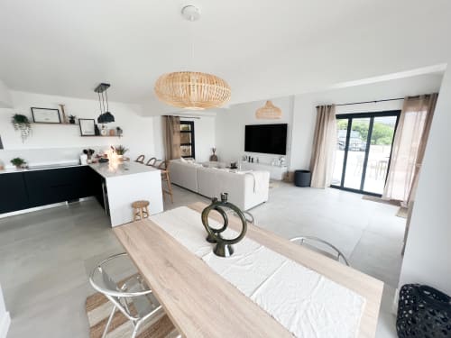 Espace ouvert Anne Duval à Saint-Florent avec table à manger, cuisine et coin salon